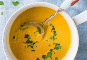 Bowl of carrot ginger soup with parsley garnish